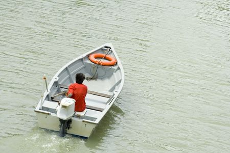 Back view of a Malay man on a moving speedboatの写真素材