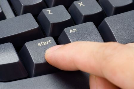 Closeup of a finger pressing START button on a keyboard
