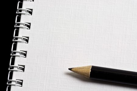 Pencil on top of a notepad with textured paper