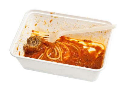 Leftover meatball spaghetti in a disposable container isolated on white background