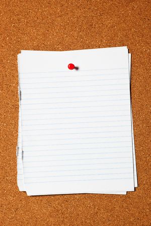 Pieces of writing paper pinned on corkboard