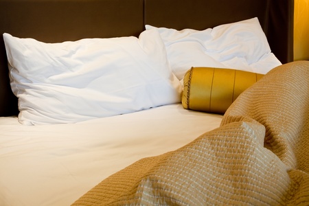 Messy luxurious bed with pillow and quilt coverの写真素材