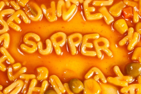 Alphabet shaped pasta forming the word SUPPER in tomato sauceの写真素材
