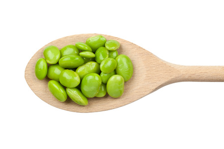 Green soybeans on wooden spoon isolated on white background