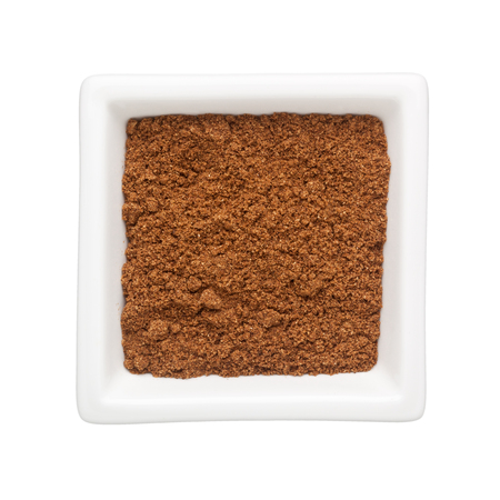 Coriander powder in a square bowl isolated on white backgroundの写真素材