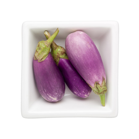 Mini eggplants in a square bowl isolated on white backgroundの写真素材
