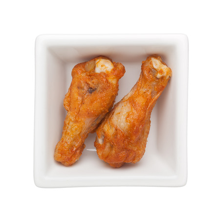 Fried chicken drumettes in a square bowl isolated on white backgroundの写真素材