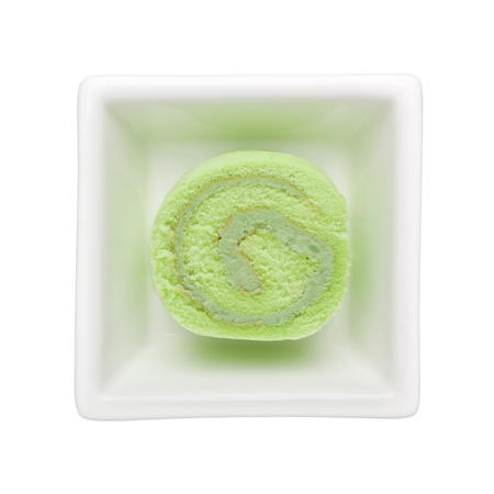 Pandan flavored Swiss roll in a square bowl isolated on white backgroundの写真素材