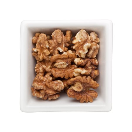Roasted walnuts in a square bowl isolated on white backgroundの写真素材