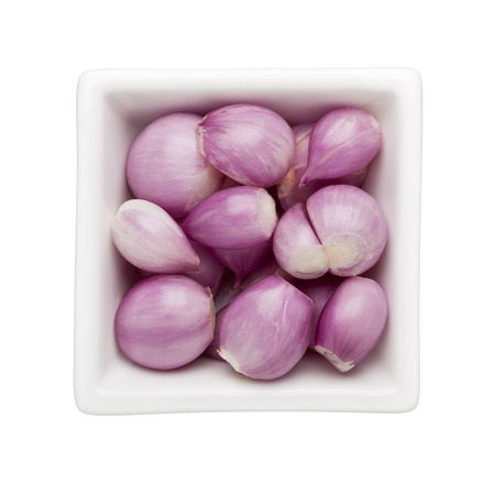 Peeled shallots in a square bowl isolated on white background
の写真素材