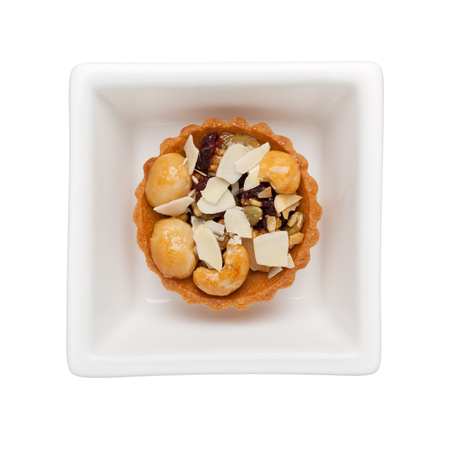Mixed nuts tart in a square bowl isolated on white background
の写真素材