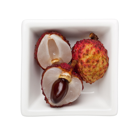 Lychees in a square bowl isolated on white backgroundの写真素材
