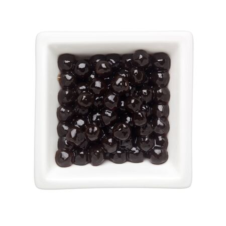 Black tapioca pearls in a square bowl isolated on white backgroundの写真素材
