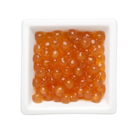 Golden tapioca pearls in a square bowl isolated on white backgroundの写真素材