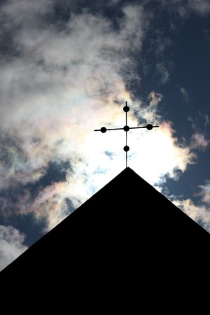 Cross on a church in front of bright sunlight.の写真素材