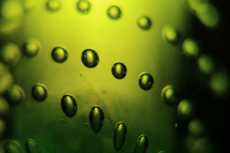 Abstract background of illuminated green bubbles.
