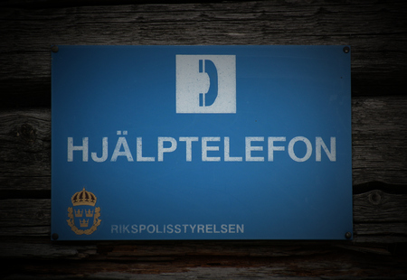 Hjälptelefon ("emergency telephone") sign in Sweden. On the botton the coat of arms of the Rikspolistyrelsen (The Swedish National Police Board) can be seen.のeditorial素材