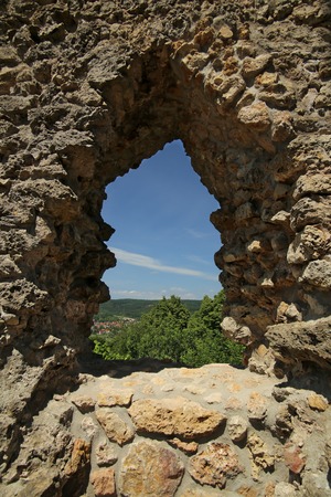 View through a small window on castle ruin Brandenburg. Some trees and a part of Herleshausen in Hesse, Germany, can be seen.の写真素材