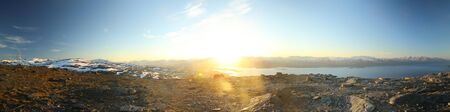 Bright panorama of midnight sun seen from the peak of Nuolja in Northern Sweden.の写真素材