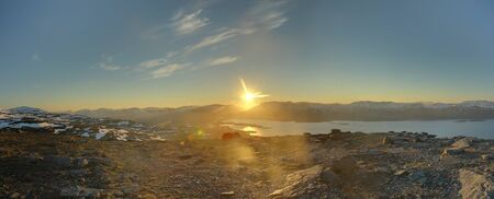 HDR Panorama of midnight sun seen from the peak of Nuolja in Northern Sweden.の写真素材