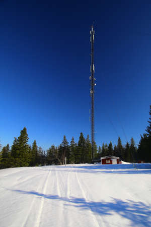 Telecommunications tower at the snowy peak of Amliden in Sweden.の写真素材