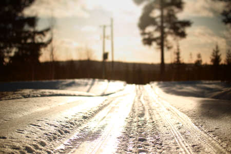 Frozen road in bright sunlight in Lapland.の写真素材