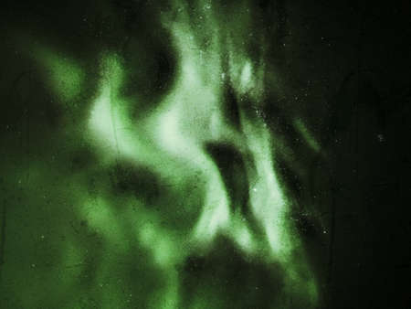Grungy upward shot of northern lights on starry sky.