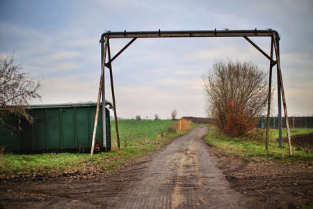 Dirty rural scene with road, pipe and container.の写真素材