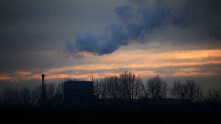 Industrial silhouette with fumes and orange sunlight.の写真素材