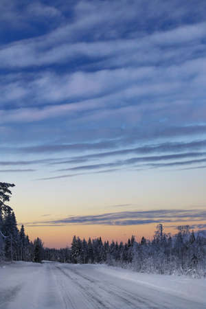 Frozen winter road with beautiful evening sky.の写真素材