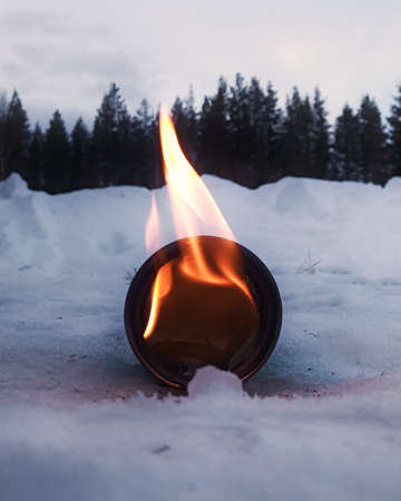 Burning glass lying in snow and ice.