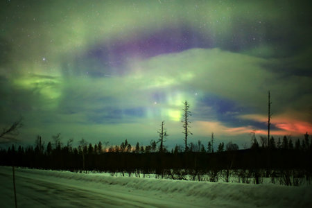 Colorful sky in northern Sweden with illuminated clouds and northern lights.の写真素材