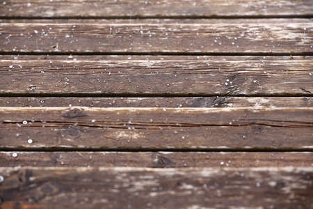 Wet wooden laths covered with some hailstones.の写真素材