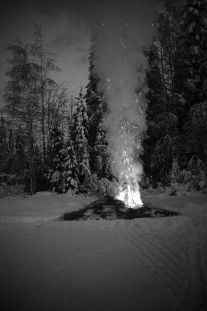 Black and white shot of bonfire with big column of smoke in the snow.の写真素材