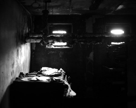 Black and white shot of desolate workplace in the basement with lots of paperwork.