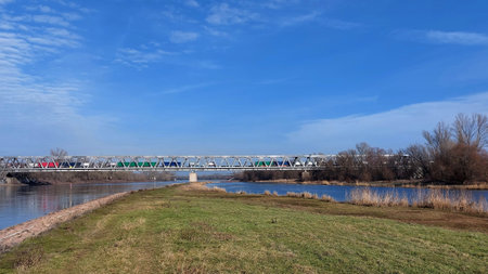 Freight train passing railway bridge over the Elbe River on a sunny winter day.の写真素材