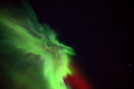 Red and green aurora formation on starry sky.の写真素材