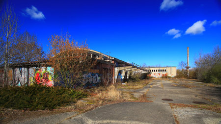 Factory ruins with smokestack on a sunny day in Germany.の写真素材