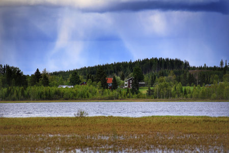 Swedish houses at a lake during rainy weather.の写真素材