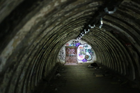 Abandoned tunnel bunker, partially illuminated by a flashlight.の写真素材