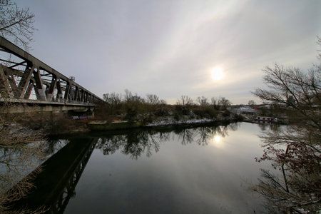 View over river Elbe with bridge and winter sun behind clouds.の写真素材