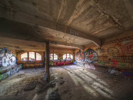 Urban interior of former slaughterhouse with sunlight streaming through arched windows and brick walls.の写真素材