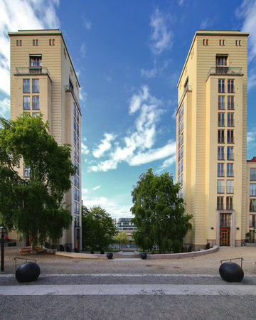 Twin towers rise symmetrically over a minimalist urban courtyard in Stockholm framed by trees and sky.の写真素材