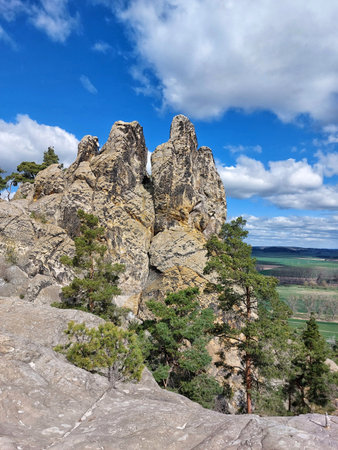 Sandstone cliffs, called Hamburger Wappen in Germany, overlook a wide valley with scattered pine trees and dramatic cloud cover.の写真素材