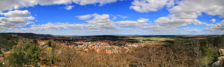 Wide valley panorama showing clustered town rooftops of Ballenstedt and open fields under scattered clouds.の写真素材