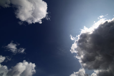 Darkening cumulus clouds with strong contrast and sun halo in late afternoon sky.の写真素材