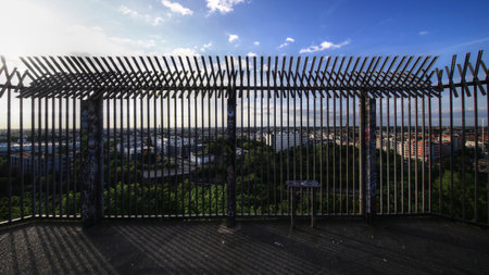 Metal fence shadows cast across a lookout platform on Flak tower III above Berlin city.