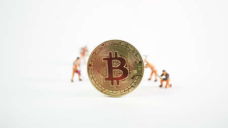 Cryptocurrency mining concept, miniature worker on various golden physical digital money bitcoin