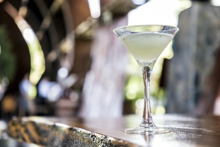 Lemon juice in a cocktail glass. Welcome drink on the wooden table in a hotel. Selective focus.の写真素材