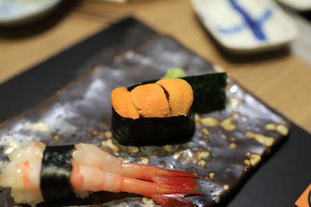Sea urchin sushi wrapped in seaweed on a traditional Japanese dishの写真素材